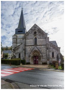 Église fortifiée Notre-Dame d’Aubenton, bâtie en pierre calcaire au cœur de la Thiérache, avec son clocher-tour massif et ses murs épais typiques de l’architecture défensive médiévale, entourée de verdure et du bocage thiérachien.