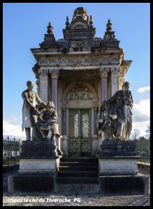 Chapelle funéraire de la famille Savart au cimetière de Saint-Michel, monument néo-classique en pierre avec fronton sculpté, colonnes et statues allégoriques encadrant l’entrée, portes ouvragées et ciel bleu en arrière-plan.