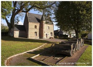 Maison du Prévôt à Saint-Michel, bâtisse en briques typiquement thiérachienne entourée d’arbres majestueux et d’espaces verts, avec au premier plan une ancienne charrette en bois exposée près d’une allée pavée, sous une belle lumière automnale.