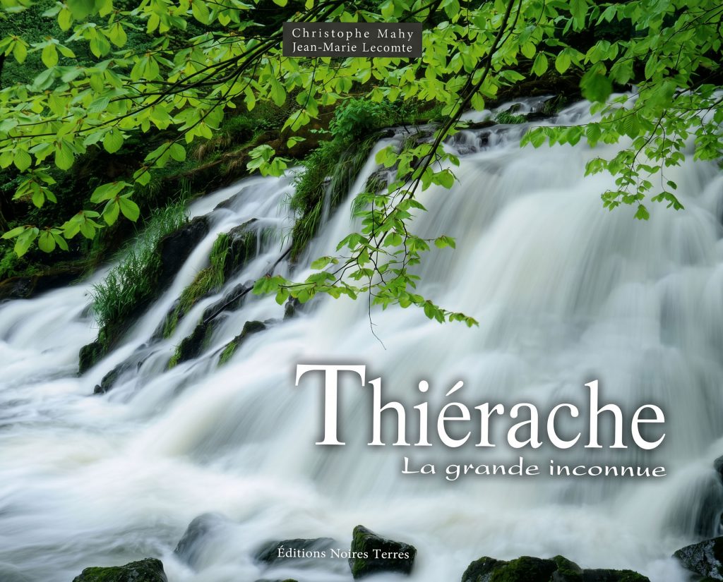 Couverture du livre Thiérache, la grande inconnue de Christophe Mahy et Jean-Marie Lecomte. La photographie montre une cascade d’eau vive coulant sur des rochers moussus au cœur d’une végétation verdoyante. Des branches aux feuilles vert clair encadrent la scène naturelle. Le titre du livre apparaît en grandes lettres blanches sur l’image, avec la mention des Éditions Noires Terres en bas de couverture.