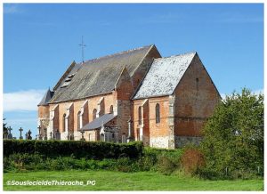 Vue latérale de l'église fortifiée Saint-Rémi de Marly-Gomont, en Thiérache (Aisne), mettant en valeur son imposante nef en briques et en grès, ses contreforts, ses échauguettes défensives et le cimetière qui l'entoure, au cœur du paysage bocager thiérachien.